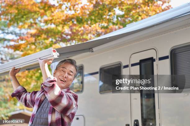 elderly, silver life, camping, camping trailer, fall, active senior, awning - installing blinds stock pictures, royalty-free photos & images