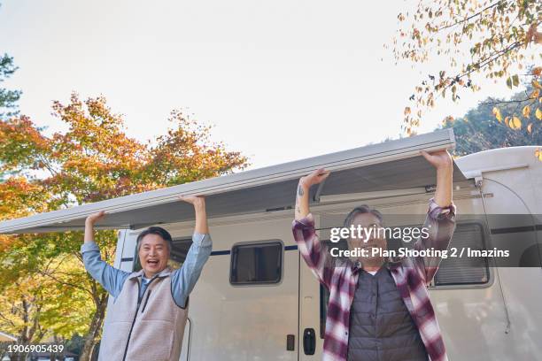 elderly, silver life, camping, camping trailer, fall, active senior, awning, smile - installing blinds stock pictures, royalty-free photos & images