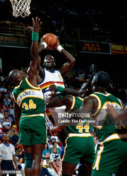 Orlando Woolridge, Small Forward for the Denver Nuggets rises above the blocking Xavier McDaniel, Power Forward for the Seattle SuperSonics to shoot...