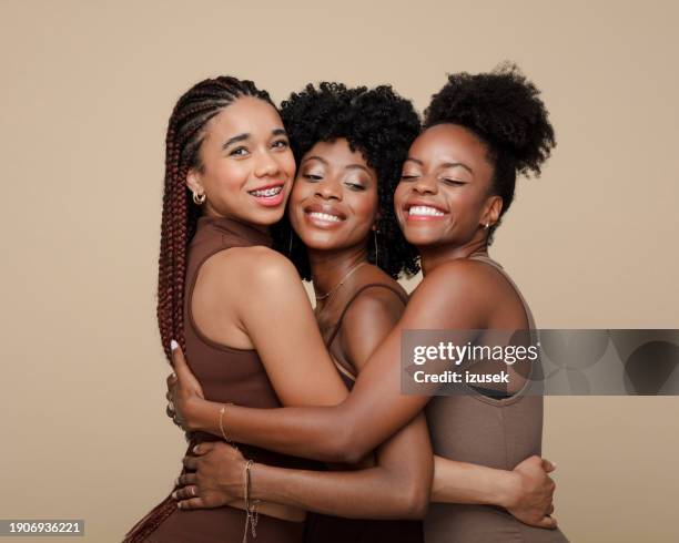 portrait of happy three young women - beige background - fotografias e filmes do acervo