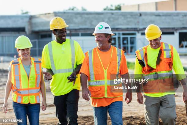 multiracial construction workers walking thru job site - construction-worker stockfoto's en -beelden