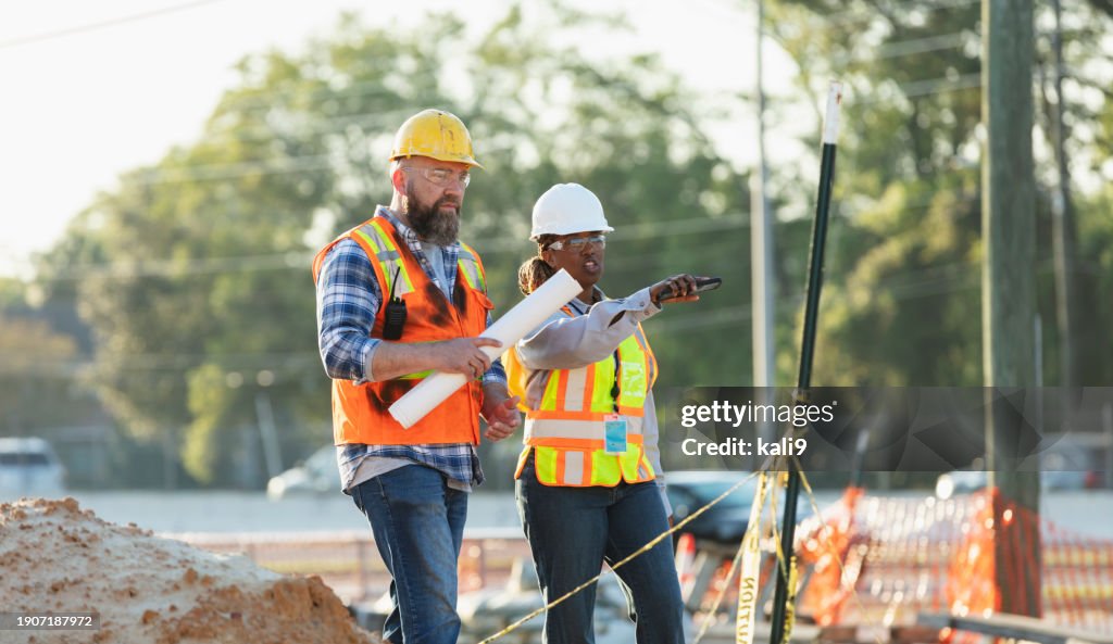 Female construction worker with coworker at job site