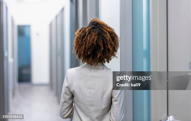 african-american businesswoman walking down hallway - black woman back of head stock pictures, royalty-free photos & images
