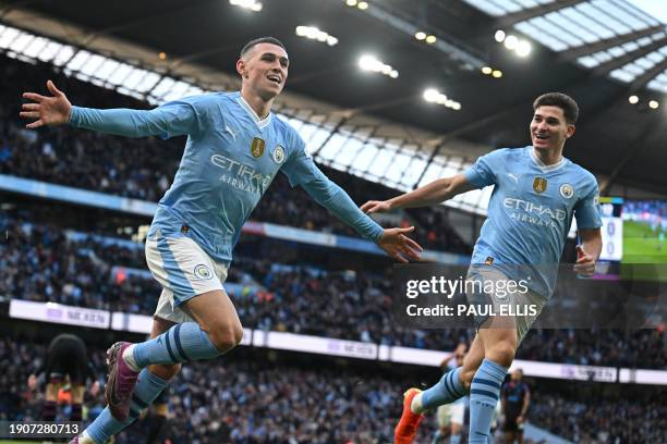 Manchester City's English midfielder Phil Foden celebrates with Manchester City's Argentinian striker Julian Alvarez after scoring the opening goal...