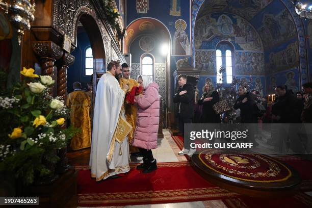 Members of the clergy offer communion during a service of the Nativity of Christ Liturgy at the Serbian Orthodox Church of the Holy Prince Lazar in...