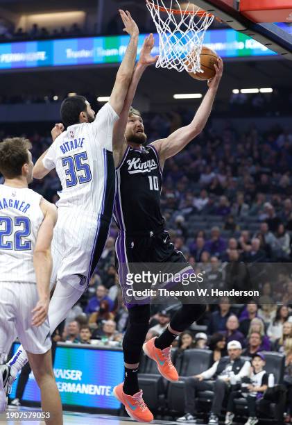 Domantas Sabonis of the Sacramento Kings shoots over Goga Bitadze of the Orlando Magic during the first half of an NBA basketball game at Golden 1...