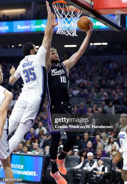 Domantas Sabonis of the Sacramento Kings shoots over Goga Bitadze of the Orlando Magic during the first half of an NBA basketball game at Golden 1...