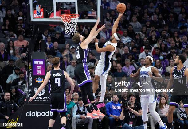 Jalen Suggs of the Orlando Magic shoots over Domantas Sabonis of the Sacramento Kings during the first half of an NBA basketball game at Golden 1...