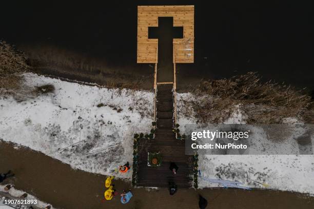 Orthodox believers are bathing in the icy waters of the Dnipro River at a place formed like a cross for Epiphany in Kyiv, Ukraine, on January 6,...