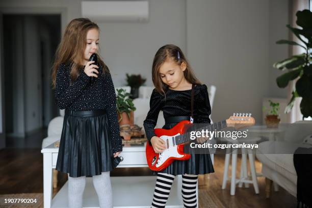 cute girls playing guitar and singing - gig living room stock pictures, royalty-free photos & images