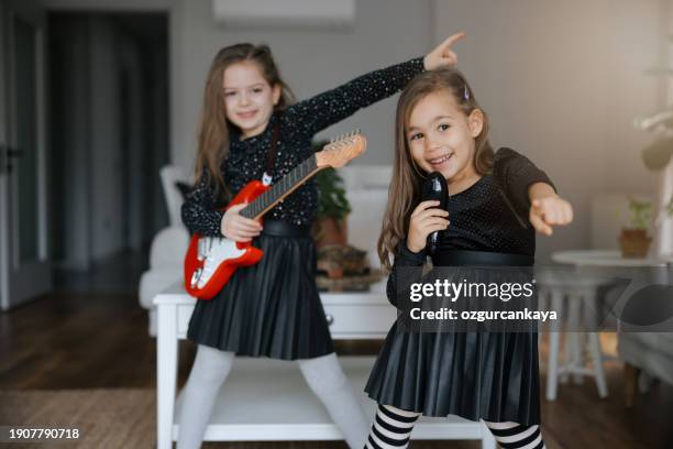 cute girls playing guitar and singing - gig living room stock pictures, royalty-free photos & images