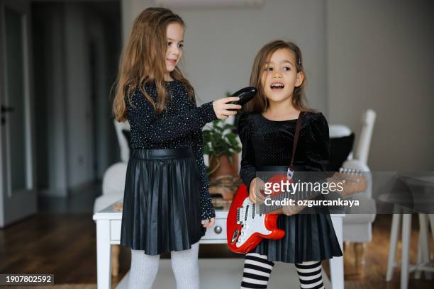 cute girls playing guitar and singing - gig living room stock pictures, royalty-free photos & images