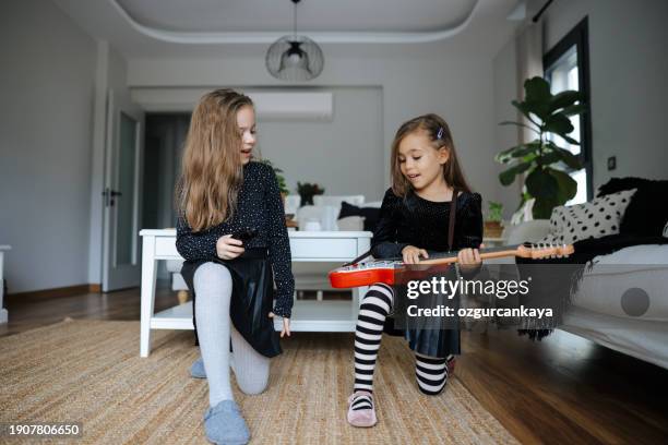 cute girls playing guitar and singing - gig living room stock pictures, royalty-free photos & images