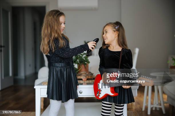 cute girls playing guitar and singing - gig living room stock pictures, royalty-free photos & images