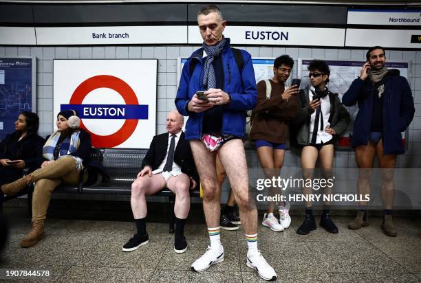 People take part in the annual "No Trousers On The Tube Day" as they wait for the metro at Euston station, on the London Underground, in London, on...