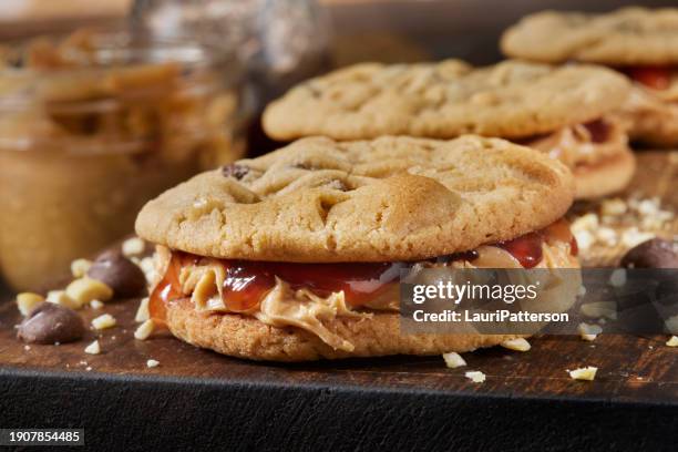 chocolate chip, peanut butter and strawberry jam cookie sandwich's - peanut butter and jelly sandwich stock pictures, royalty-free photos & images