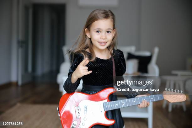 expressive emotional caucasian girl of primary school age sings along with herself on the electric guitar - electric guitarist stock pictures, royalty-free photos & images