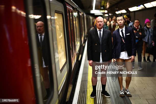 People taking part in the annual "No Trousers On The Tube Day" , wait for the metro at a station in the London Underground, in London, on January 7,...