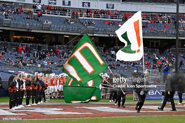 Miami's cheerleaders lift banners to lead the team onto the field prior to the game as the Miami Hurricanes faced the Rutgers Scarlett Knights on...