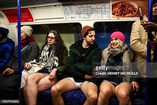 People taking part in the annual "No Trousers On The Tube Day" , wait for the metro at a station in the London Underground, in London, on January 7,...