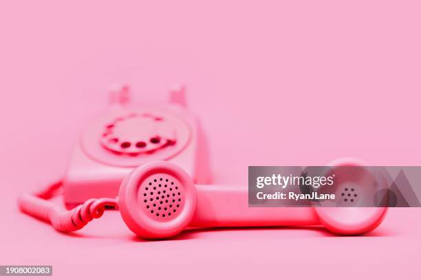 retro pink rotary telephone on pink background - vaste telefoon stockfoto's en -beelden