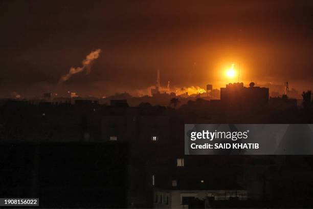 Israeli bombardment lights the skyline of Khan Yunis, pictured from Rafah in the southern Gaza Strip late on January 7, 2024 amid the ongoing...