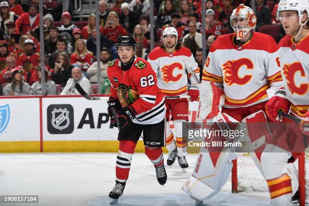 Brett Seney of the Chicago Blackhawks skates next to goalie Dan Vladar of the Calgary Flames in the first period at the United Center on January 07,...