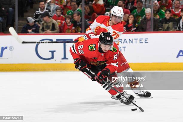 Brett Seney of the Chicago Blackhawks grabs the puck against Martin Pospisil of the Calgary Flames in the second period at the United Center on...