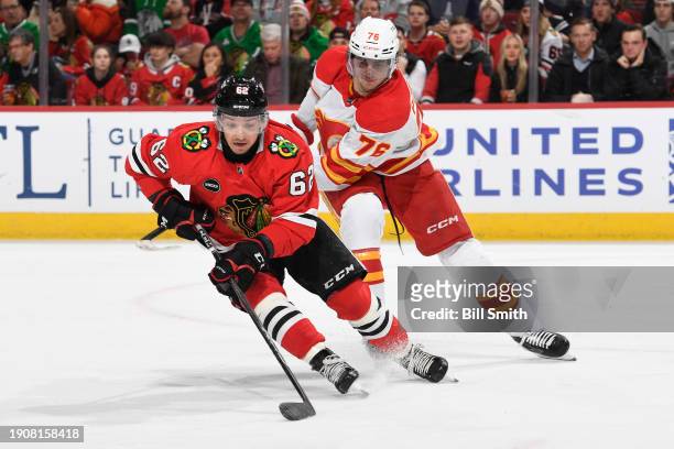Brett Seney of the Chicago Blackhawks grabs the puck ahead of Martin Pospisil of the Calgary Flames in the second period at the United Center on...