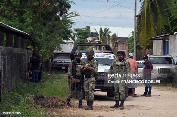 Soldiers stand guard and inspect the area outside a palenque, where cock fights take place, a day after five people were killed and 20 injured in an...