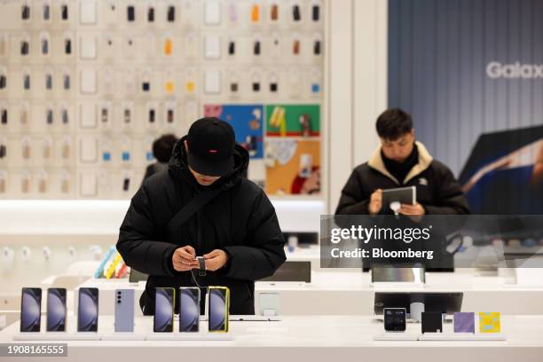 Customer, left, tries out a Samsung Electronics Co. Galaxy Watch6 smartwatch at the Samsung Store in Seoul, South Korea, on Sunday, Jan. 7, 2024. The...