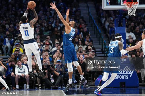 Kyrie Irving of the Dallas Mavericks shoots the ball while Rudy Gobert of the Minnesota Timberwolves goes up for the block during the game on January...