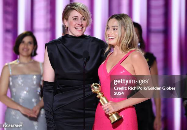 Greta Gerwig and Margot Robbie accepts the award for Cinematic and Box Office Achievement for "Barbie" at the 81st Golden Globe Awards held at the...