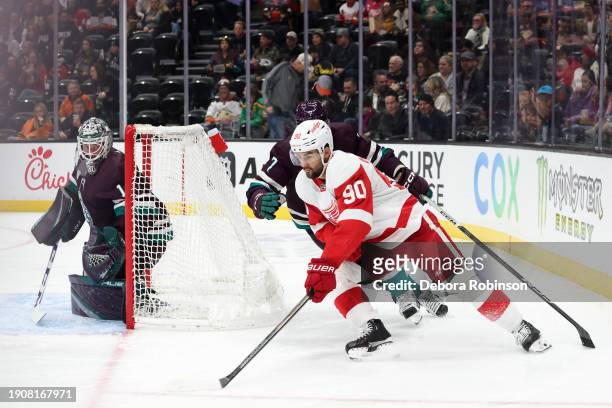 Joe Veleno of the Detroit Red Wings skates with the puck as Lukas Dostal of the Anaheim Ducks holds the crease during the game on January 7, 2024 at...