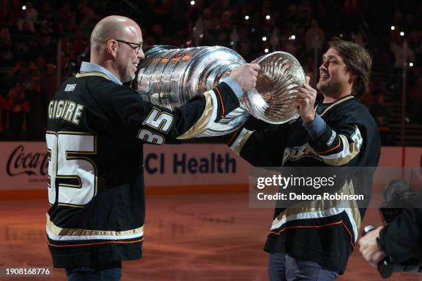 Anaheim Ducks alumni, Jean-Sebastien Giguere and Teemu Selanne pass the Stanley Cup during Legacy Night prior to the game against the Detroit Red...