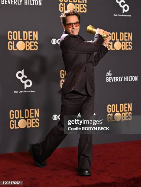 Actor Robert Downey Jr. Poses in the press room with the award for Best Performance by a Male Actor in a Supporting Role in any Motion Picture for...