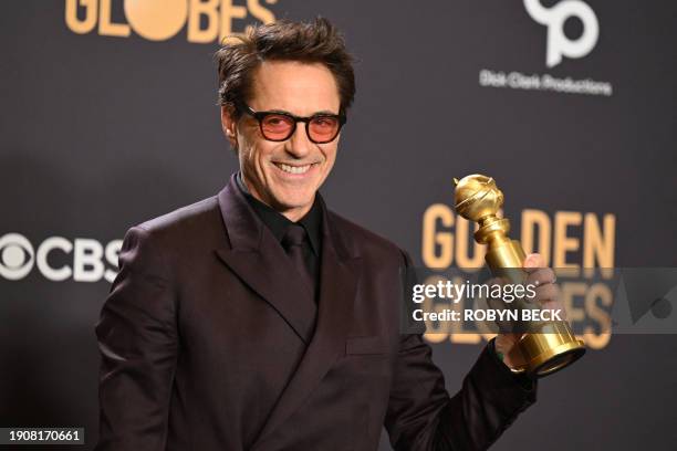 Actor Robert Downey Jr. Poses in the press room with the award for Best Performance by a Male Actor in a Supporting Role in any Motion Picture for...