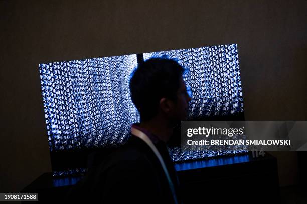 Person walks past TV screens at the Samsung First Look preview at the Caesars Palace resort a pre-show for this weeks Consumer Electronics Show...