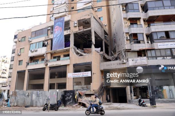 This photograph taken on January 8, 2024 shows a banner depicting Hezbollah Secretary General Hassan Nasrallah hanging on the building, which was hit...