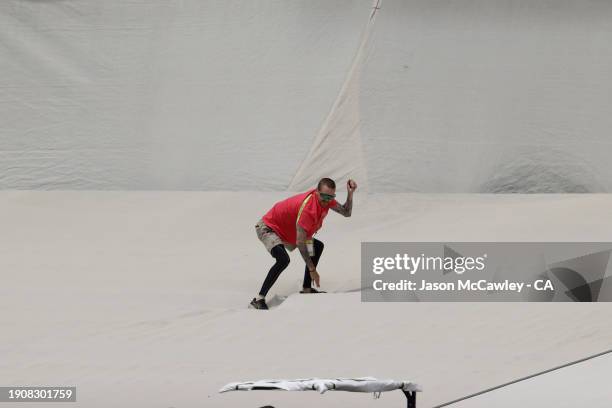 Ground staff remove rubbish off the sight screen during day three of the Men's Third Test Match in the series between Australia and Pakistan at...