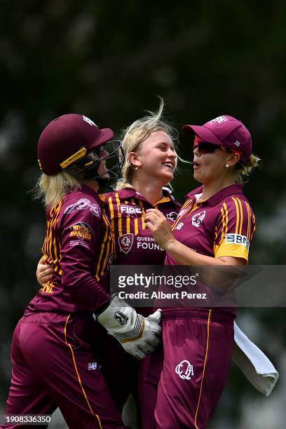 Grace Parsons of Queensland celebrates with team mates after dismissing Maddie Penna of South Australia during the WNCL match between Queensland and...