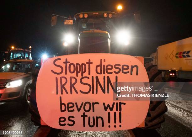 Farmer has fixed on his tractor a poster reading "Stop this madness, before we will do it!!!" during a demonstration against the federal government's...