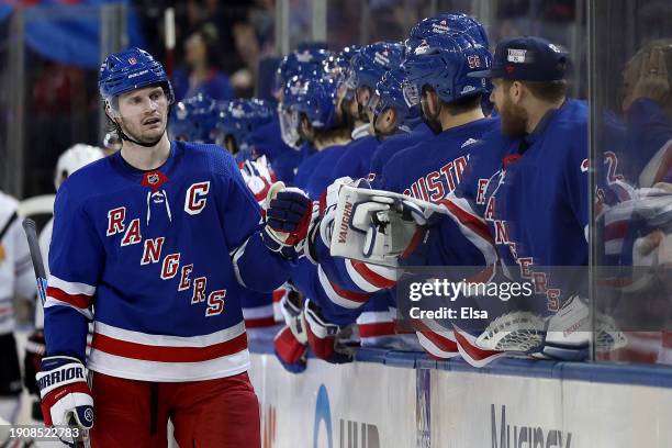 Jacob Trouba of the New York Rangers is congratulated by teammates on the bench after he scored during the third period at Madison Square Garden on...