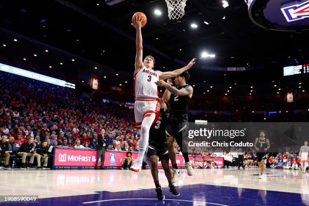 Pelle Larsson of the Arizona Wildcats goes up for a layup ahead of KJ Simpson of the Colorado Buffaloes during the first half at McKale Center on...