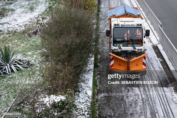 An employee of M2a drives a snow-clearing and salting vehicle on a snow-covered street in Mulhouse, eastern France, on January 8, 2024.