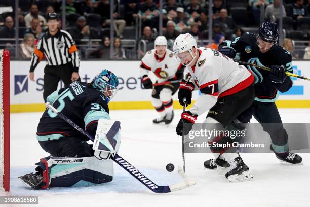 Joey Daccord of the Seattle Kraken makes a save against Brady Tkachuk of the Ottawa Senators during the first period at Climate Pledge Arena on...
