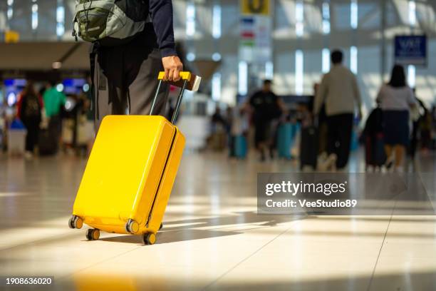 asian senior man with luggage walking in airport terminal. - bagagem imagens e fotografias de stock