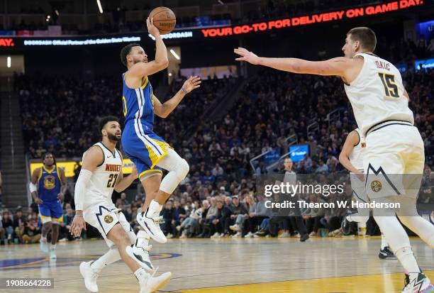 Stephen Curry of the Golden State Warriors shoots the ball against Nikola Jokic of the Denver Nuggets during the second quarter at Chase Center on...