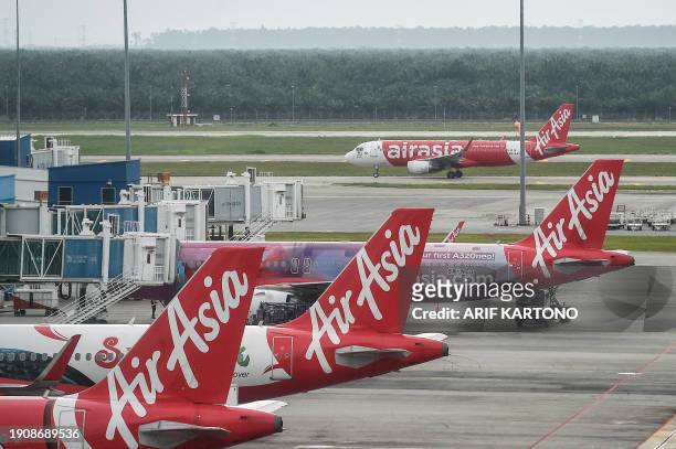 AirAsia airplanes are pictured on the tarmac at Kuala Lumpur International Airport in Sepang on January 8, 2024. Malaysian conglomerate Capital A...