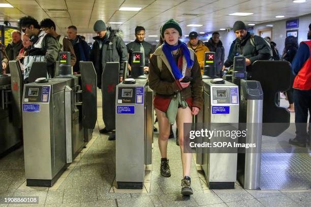 Participants take part in the annual "No Trousers Tube Ride" event as they walk past the ticket machines at King's Cross station in London. During...